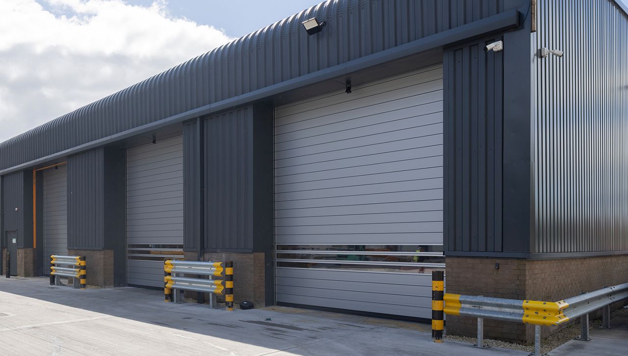 Image: Exterior view of three ASSA ABLOY RT1000 high-speed spiral doors installed in a distribution and logistics facility