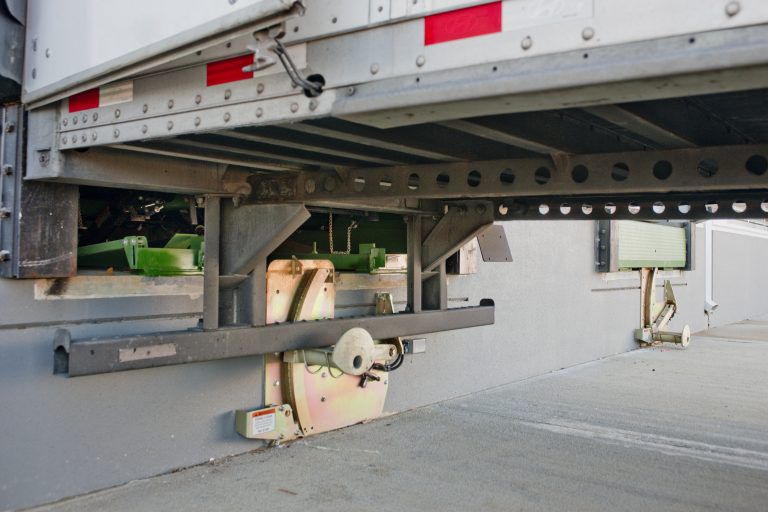A gold trailer restraint holding a semi truck in place