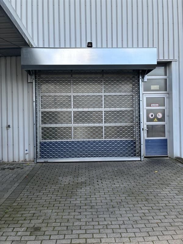 Rollgitteranlage vor einem Sektionaltor mit Fenstern und Nebentür