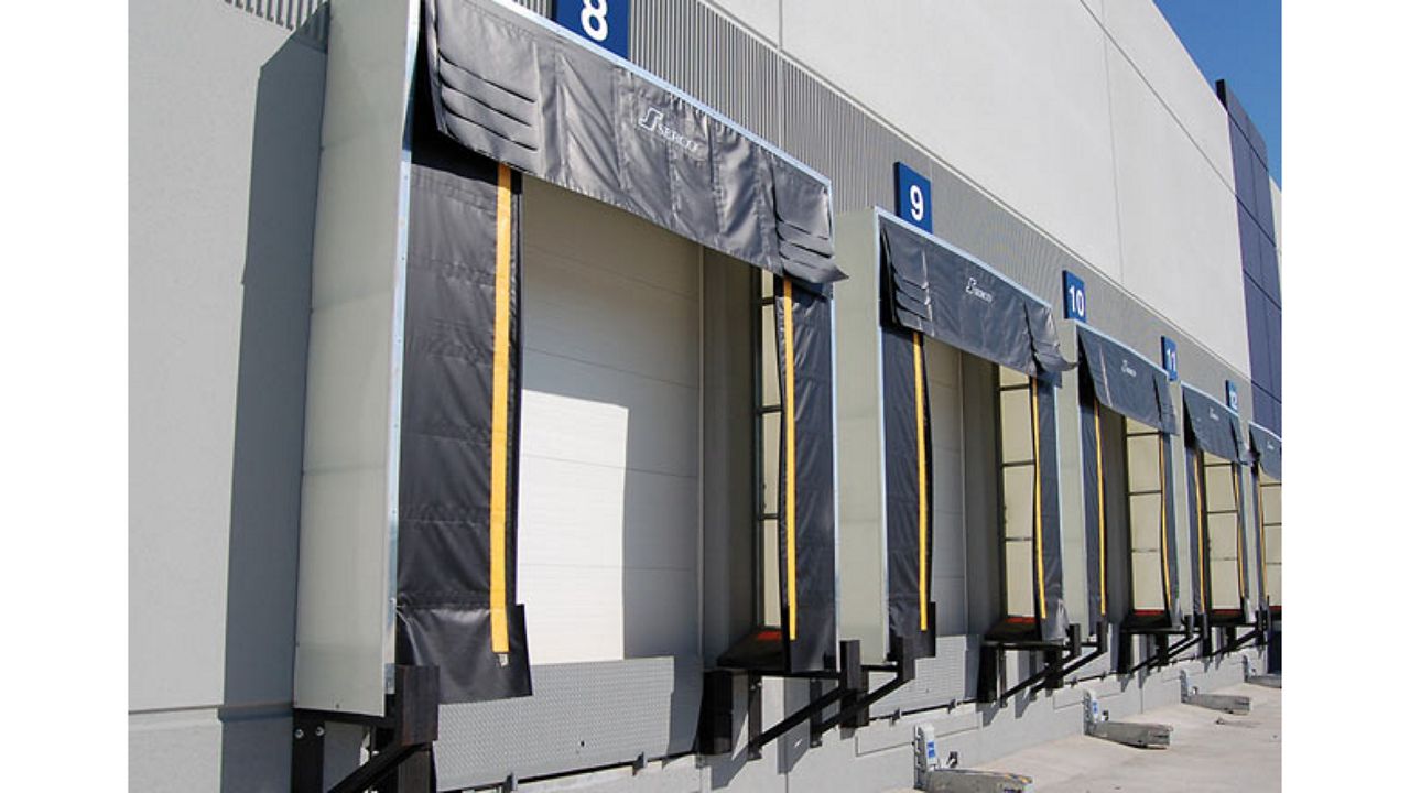 A line of doors with dock shelters on the outside of a warehouse.