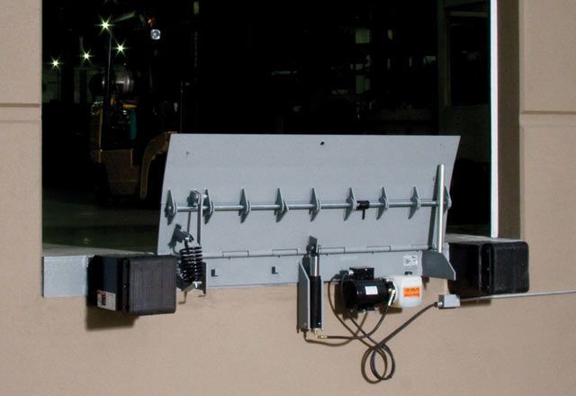 A silver edge of dock leveler attached outside of a warehouse.