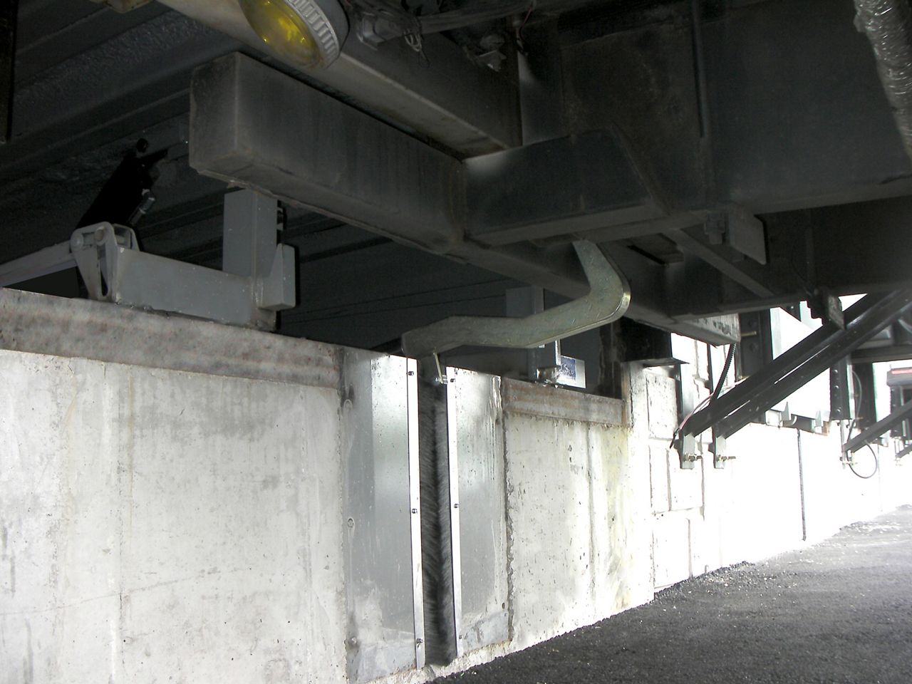 The SLP3000 Recessed Vehicle Restraint set up outside and hooking onto a truck.