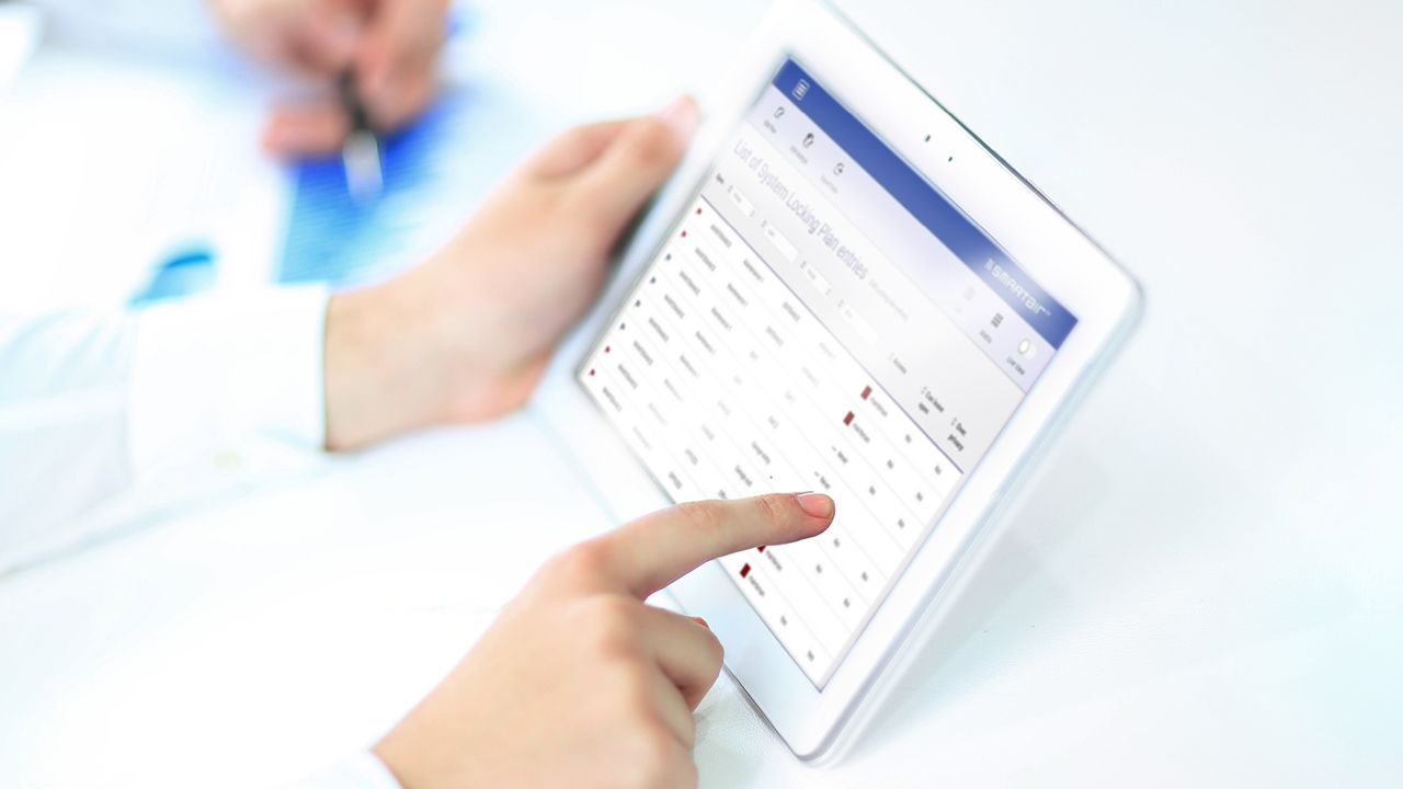 Mand sidder med en tablet i hånden