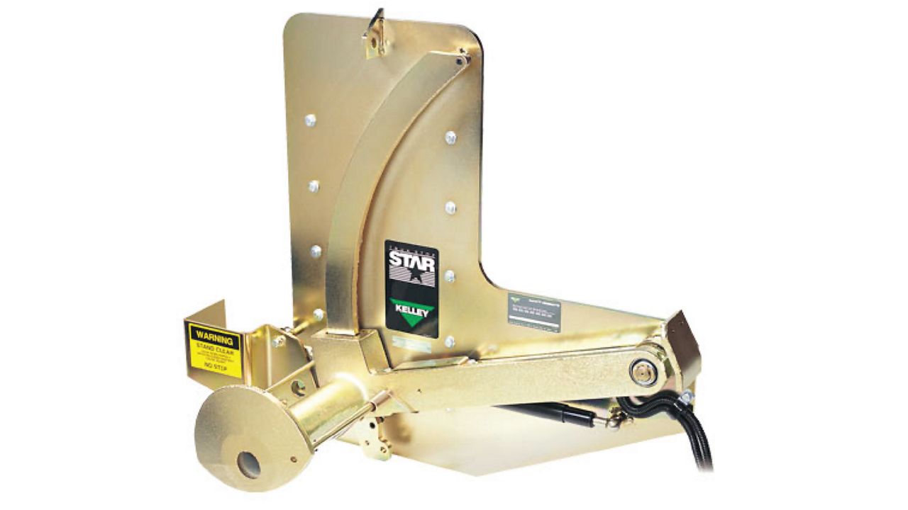 A durable gold-colored industrial device designed for securing vehicles, featuring a curved arm mechanism and safety labels.