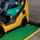 A yellow forklift being backed into a green safety barrier lip 