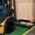 A forklift picking up a box while being held in place by a safety barrier lip