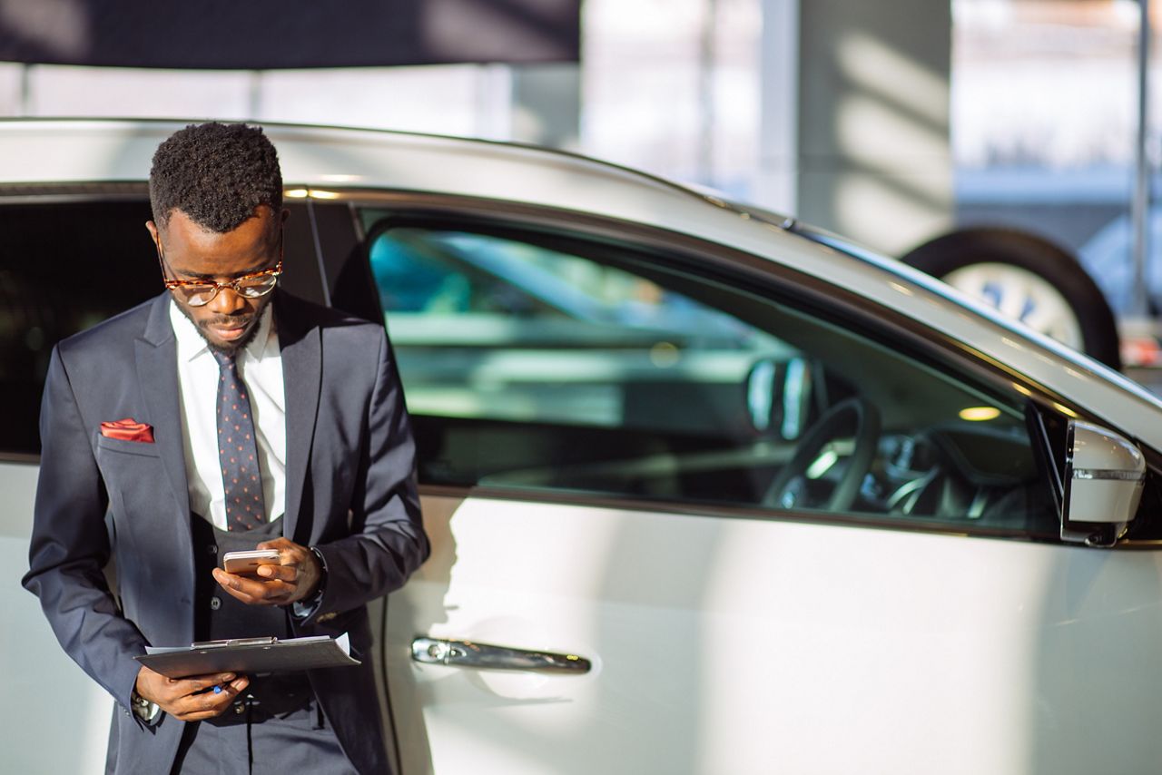 Salesman using KEYper GO in car dealership showroom