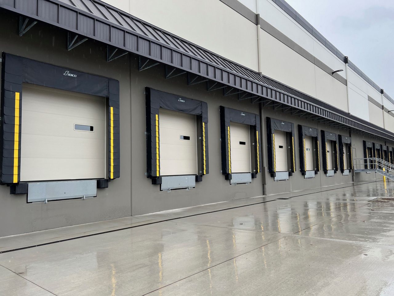 Image: A line of doors with dock seals on the outside of a warehouse.
