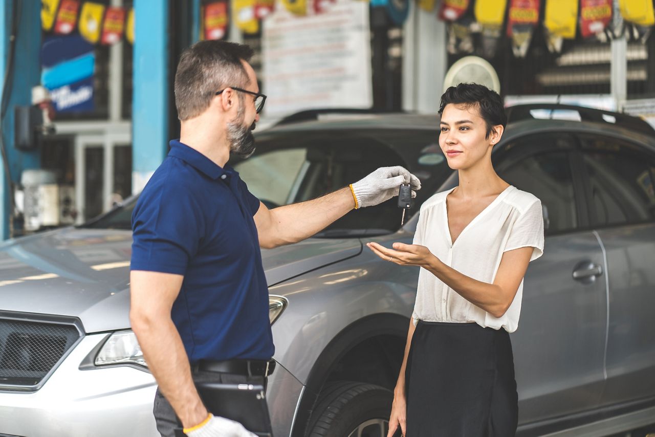 Car service technician handing keys to customer