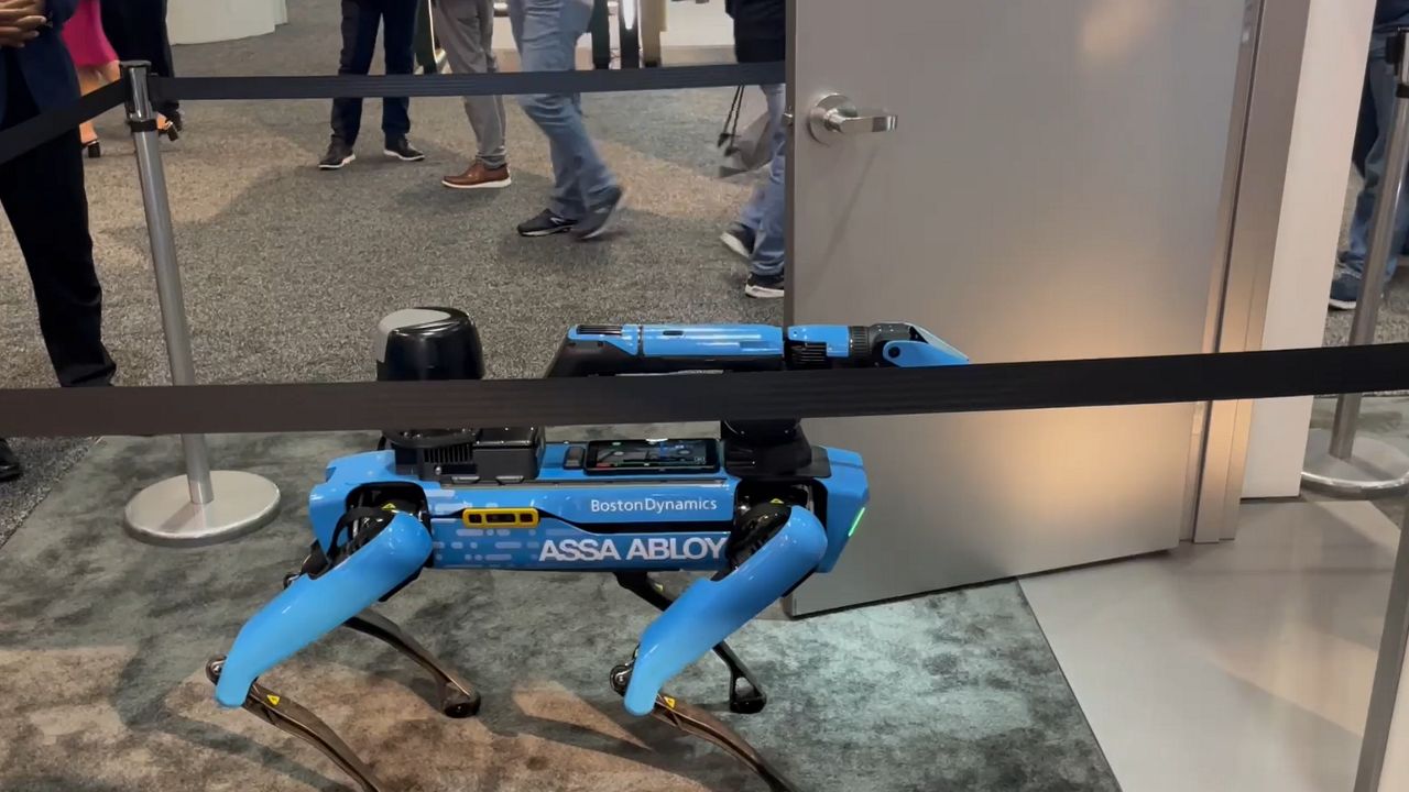 Robot dog walks through door by ASSA ABLOY.