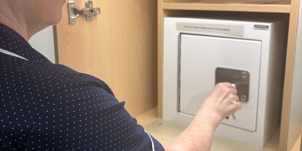 nurse accessing a medicine cabinet with a CLIQ key, medicine storage area, or St Oswald's Hospice environment