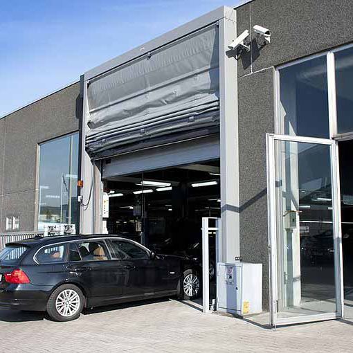 Porte automatique rapide installée dans une concession automobile pour l'accès au garage et atelier mécanique
