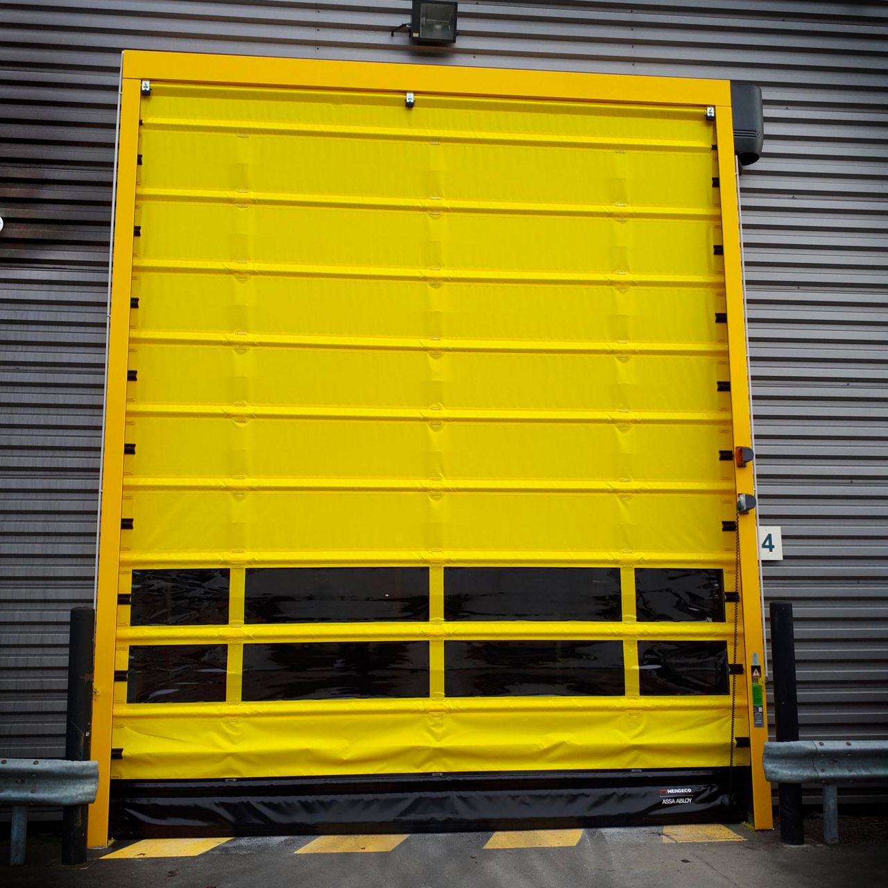 Porte automatique rapide jaune posée sur bardage métallique gris