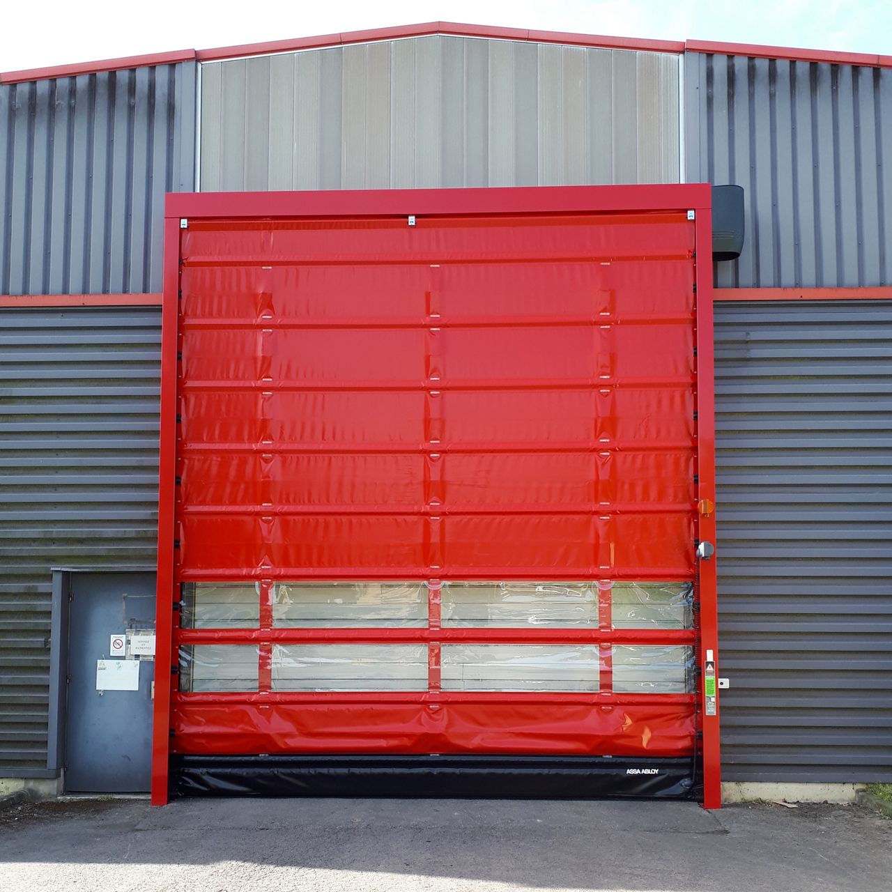 Porte automatique rapide rouge posée sur bardage métallique gris