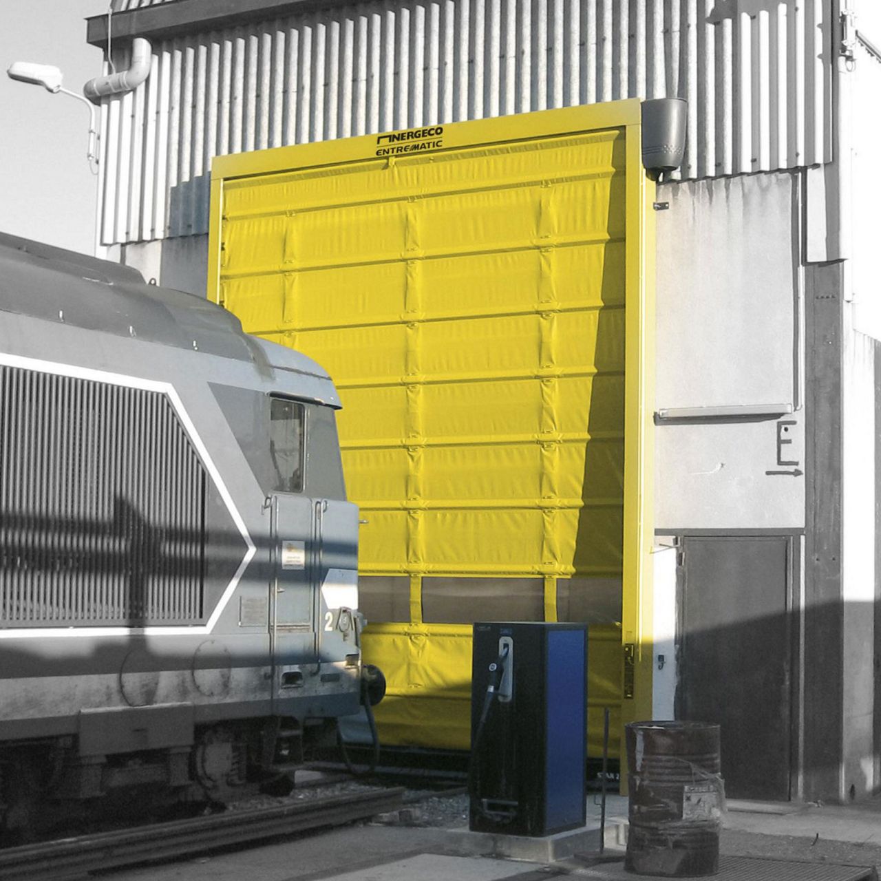 Ein gelbes Tor mit Zug im Vordergrund.