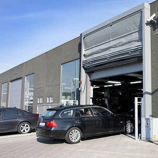 Ein offenes Garagentor, in das ein Auto ein fährt. 