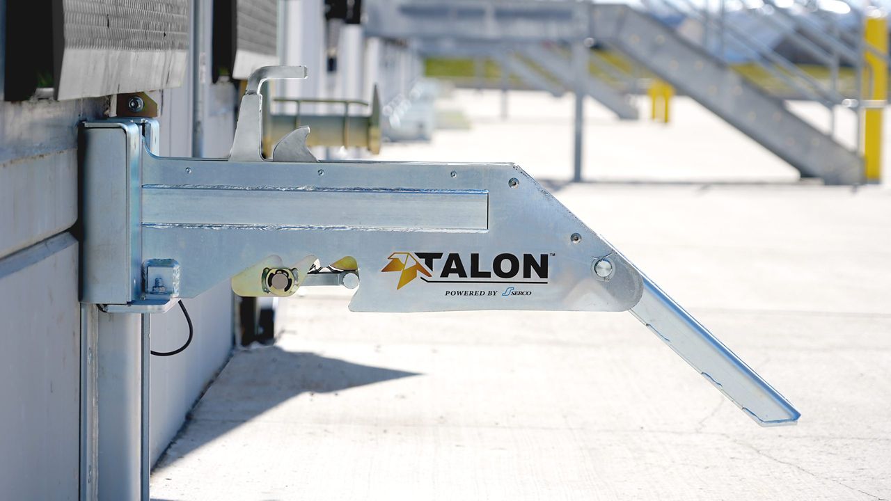 The Talon™ Trailer Restraint set up outside of a warehouse