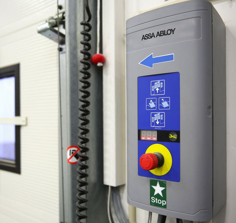 ASSA ABLOY Steuerung an der Wand neben einem Sektionaltor mit Fenster
