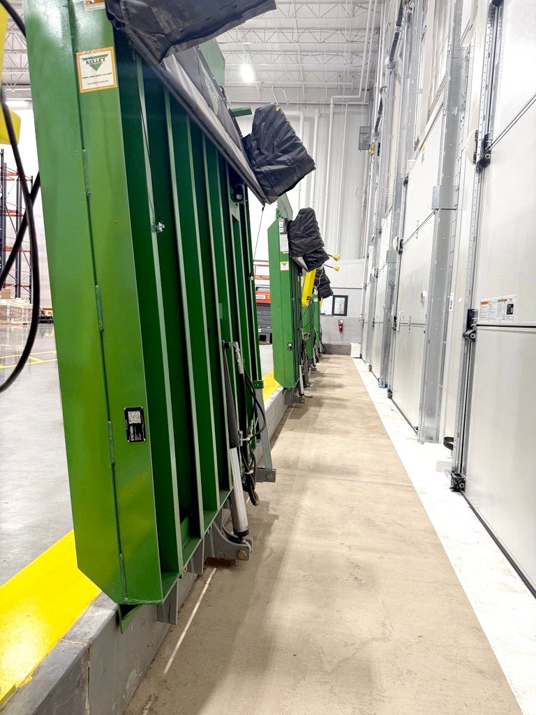 Image: Image of three vertical levelers up right in a warehouse.