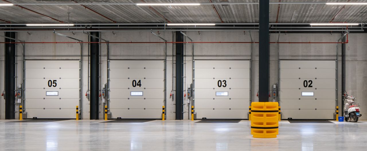 Inside of a loading dock with closed white dock doors.