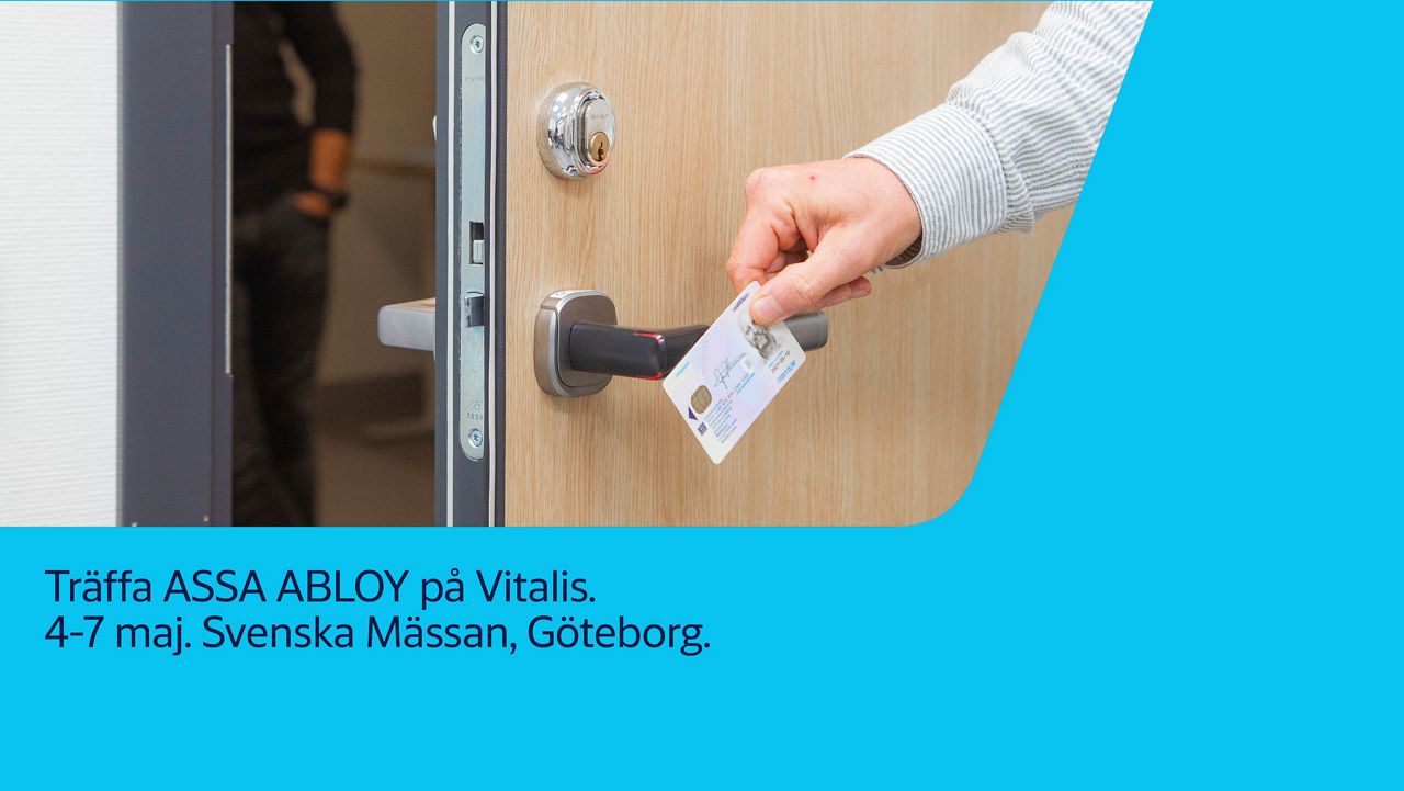 En hand som håller i ett passerkort framför en dörr.