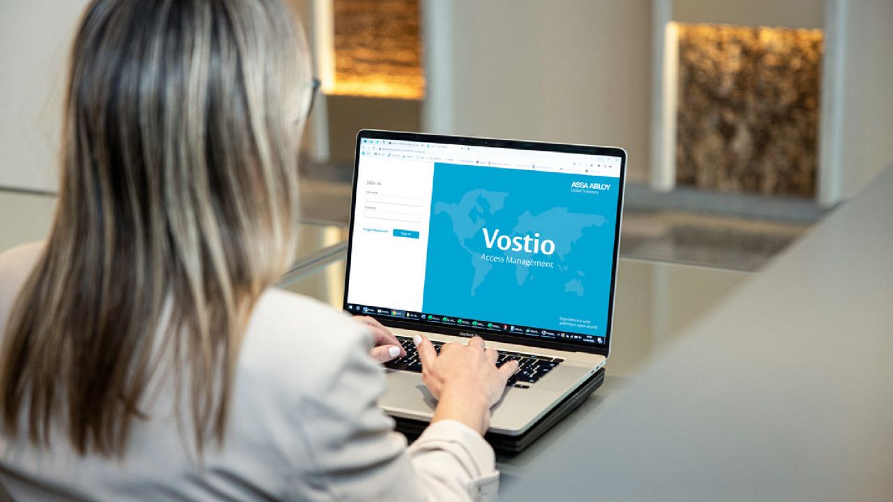 woman at desk with laptop logging on to vostio online access management