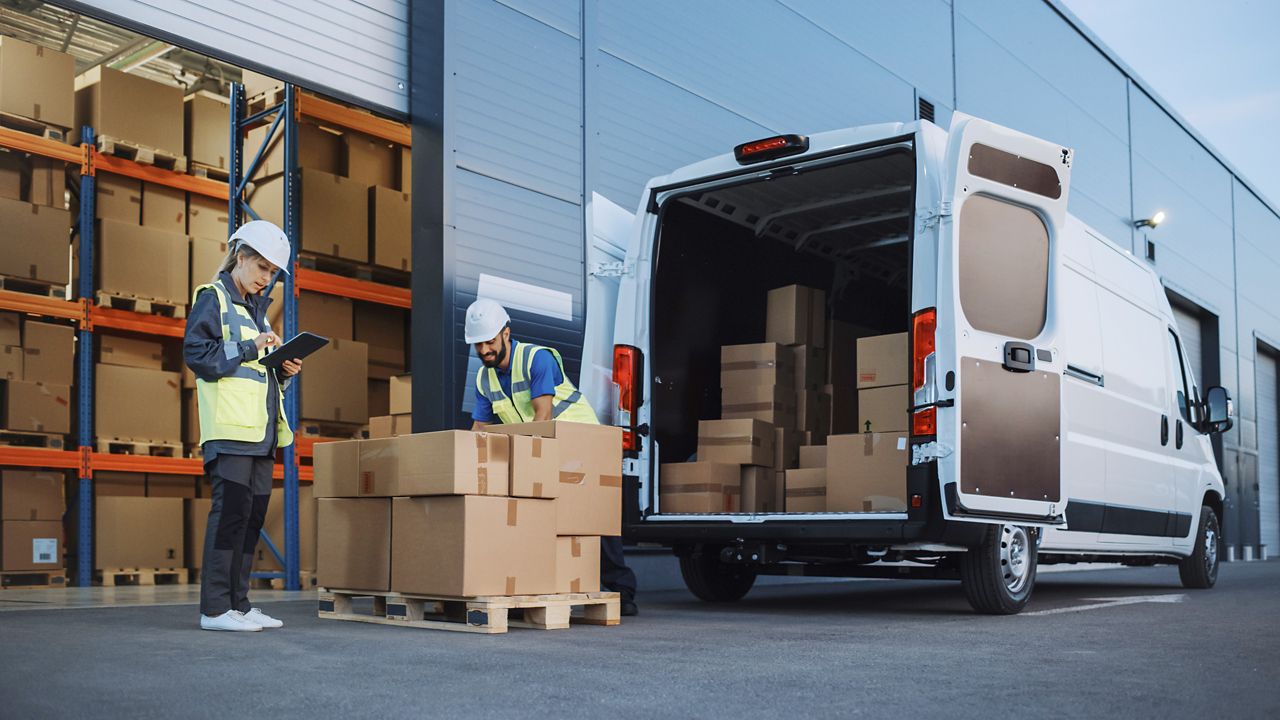 Workers loading can outside distribution warehouse
