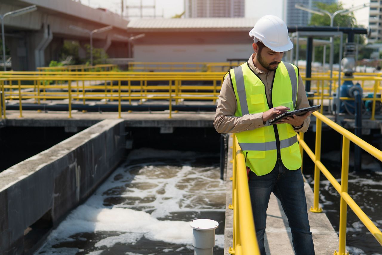 Engineer working on tablet at wastewater treatment facility