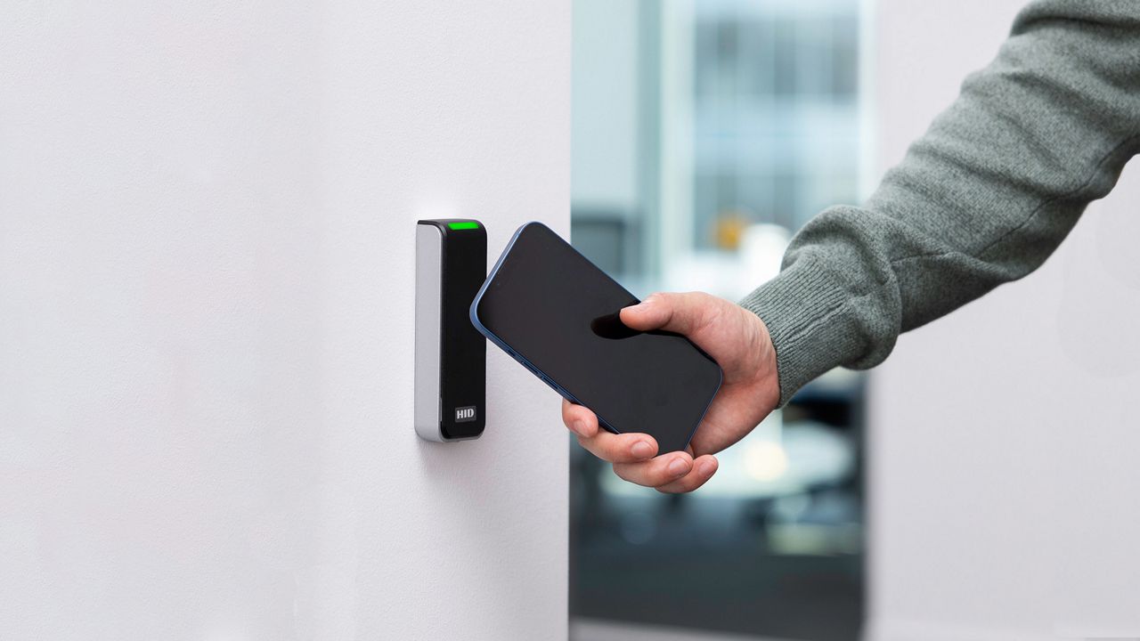 Lettore di carte HID sulla parete e un telefono cellulare