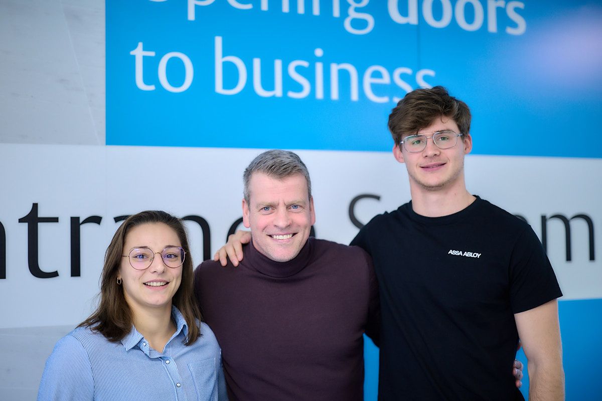 Managing Director Stig Van de Wynkele op kantoor samen met de 2 sportambassadeurs van ASSA ABLOY, Mina Libeer en Jente Hauttekeete.