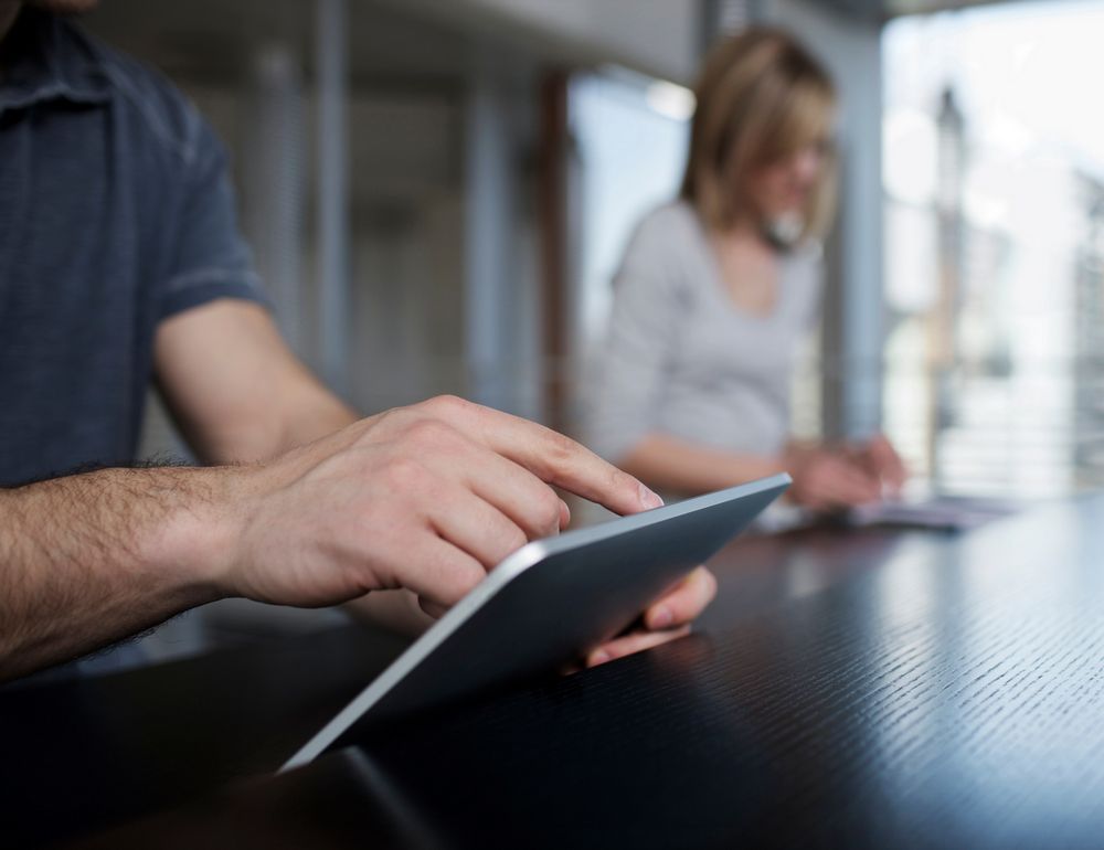 Homme naviguant sur l'application Le catalogue développé par Vachette sur une tablette