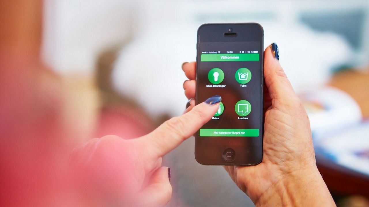 Kvinna använder Aptus på sin telefon.