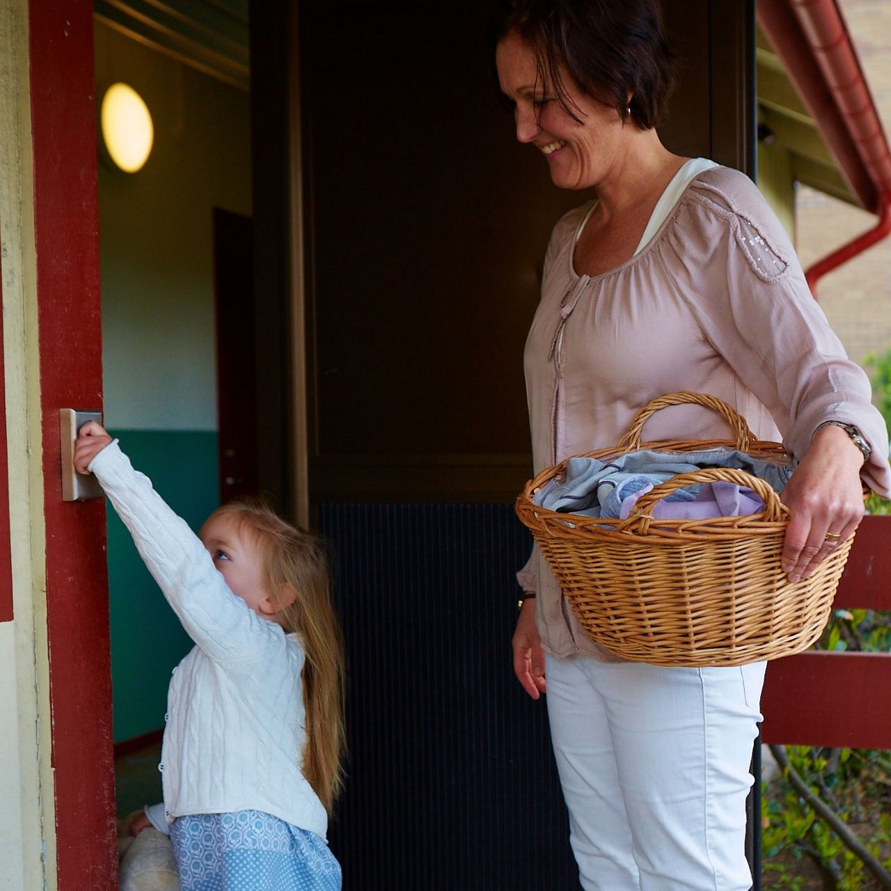 Mamma och dotter öppnar dörr till tvättrummet med Aptus nyckel.