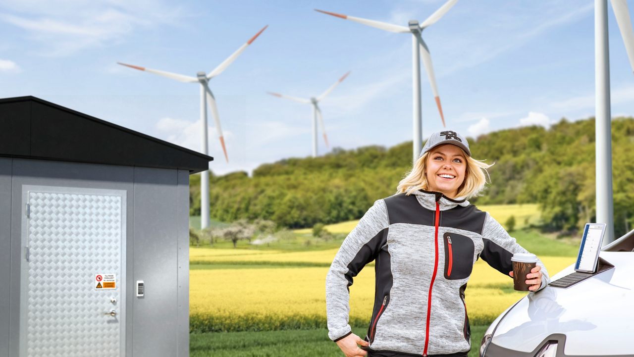 Woman standing by wind turbine.