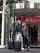 Couple with suitcases exits through revolving glass lobby doors