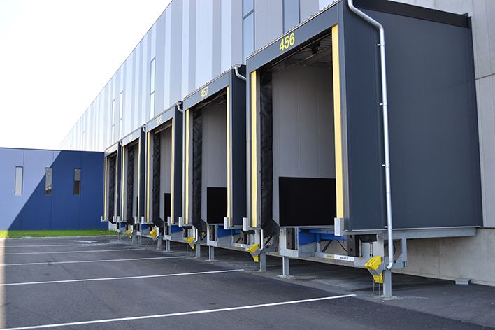 Een complete rij laadkades met ASSA ABLOY-systemen en laadhuizen voor een efficiënte en veilige overslag.