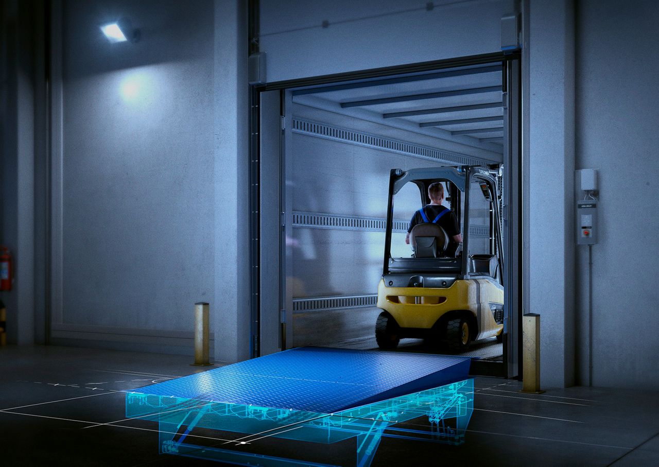 yellow forklift drives over a dock leveller in the cargo compartment of a truck