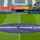Uitzicht op het voetbalstadion Planet Group Arena van KAA Gent vlak voor de aftrap van een wedstrijd. Op de middenstip ligt een ronde banner met het logo van ASSA ABLOY duidelijk zichtbaar op het grasveld.