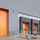 Porte sectionnelle innovante de couleur orange faisant partie d'une série de portes sectionnelles dans un centre de distribution