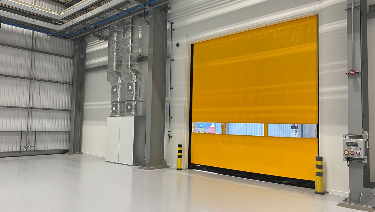 A yellow internal high speed door in a warehouse enviroment. 