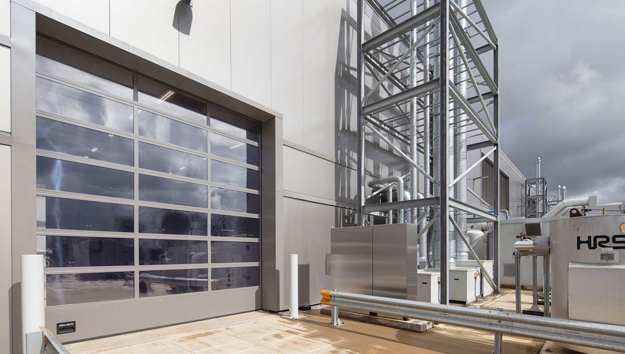 An external image of a ASSA ABLOY OH1042FI glazed insulated overhead sectional door at a UK leading manufacturing company