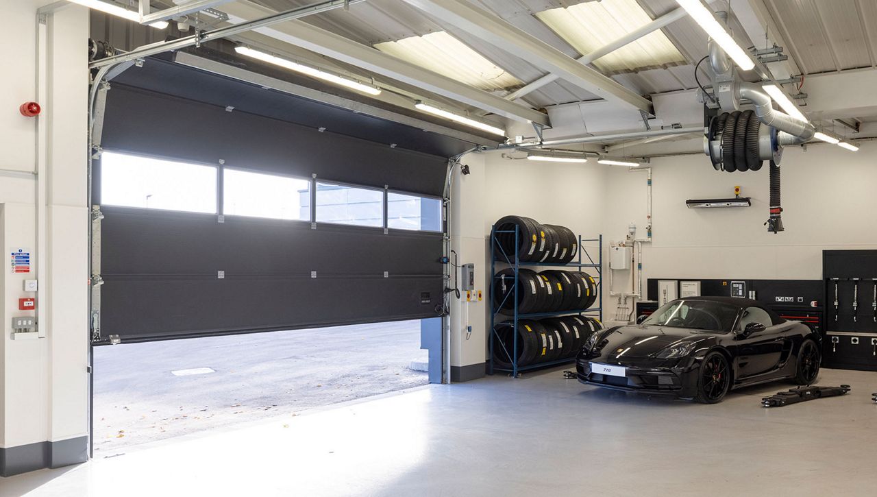 An internal image of a Crawford OH1042P overhead sectional door installed on a service bay at a Porsche garage