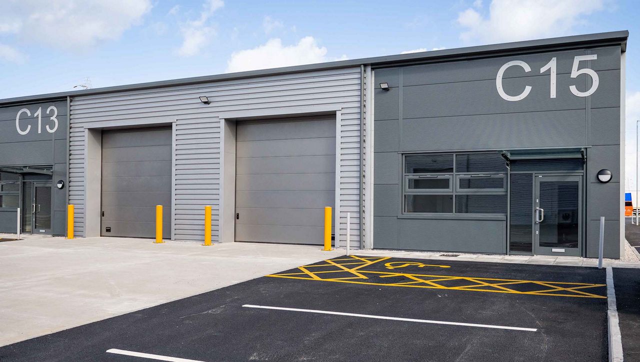 Image: An external image of a two Crawford OH1042P secured by design overhead sectional door at a Broadheath Network Space, Altrincham