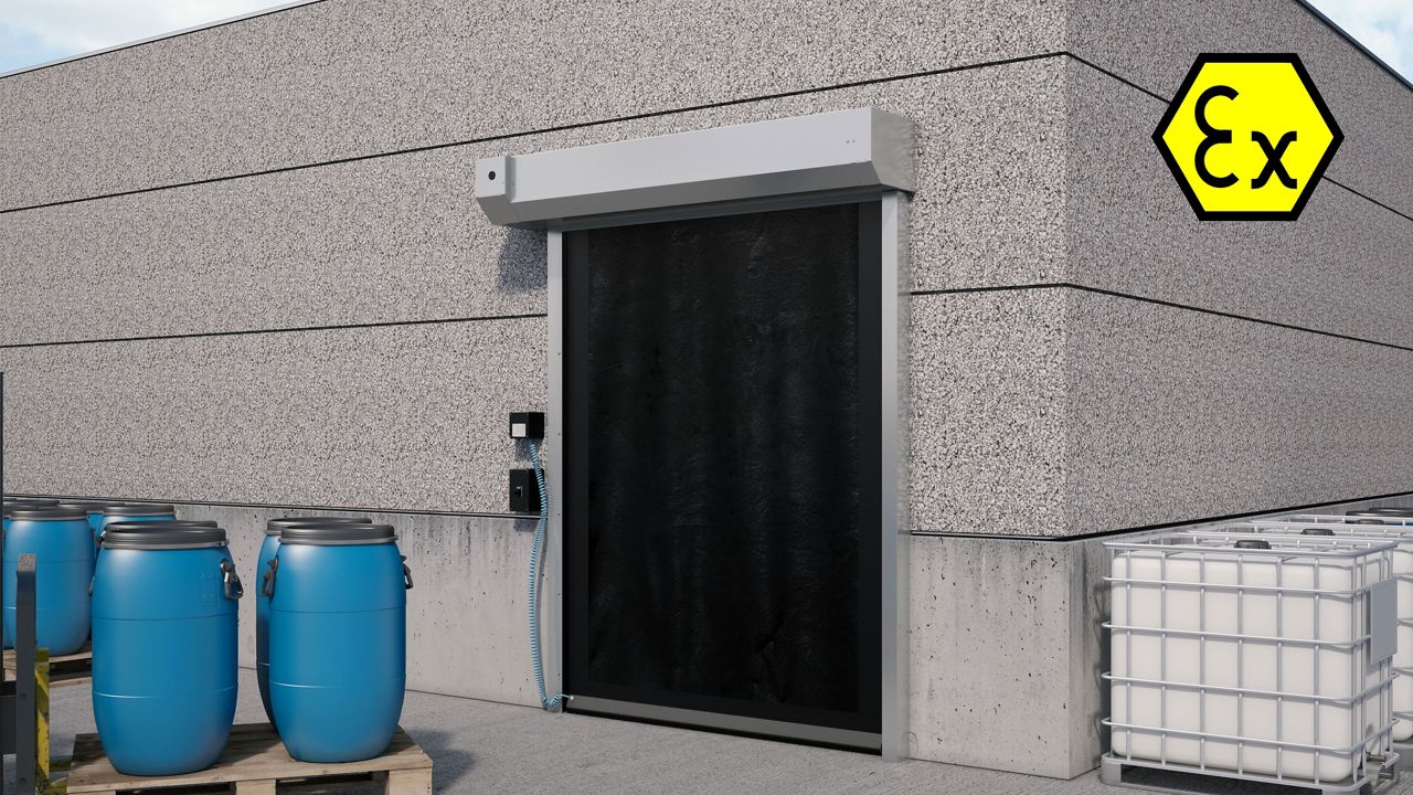 Una puerta Atex negra en un entorno explosivo, con barriles azules en el exterior. 