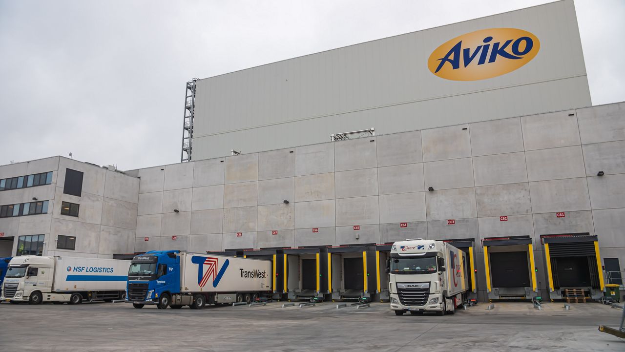 3 camions prêts à être chargés dans un bâtiment portant le logo d'Aviko