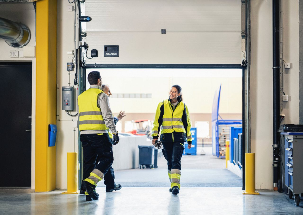 Due uomini e una donna parlano vicino a una baia di carico
