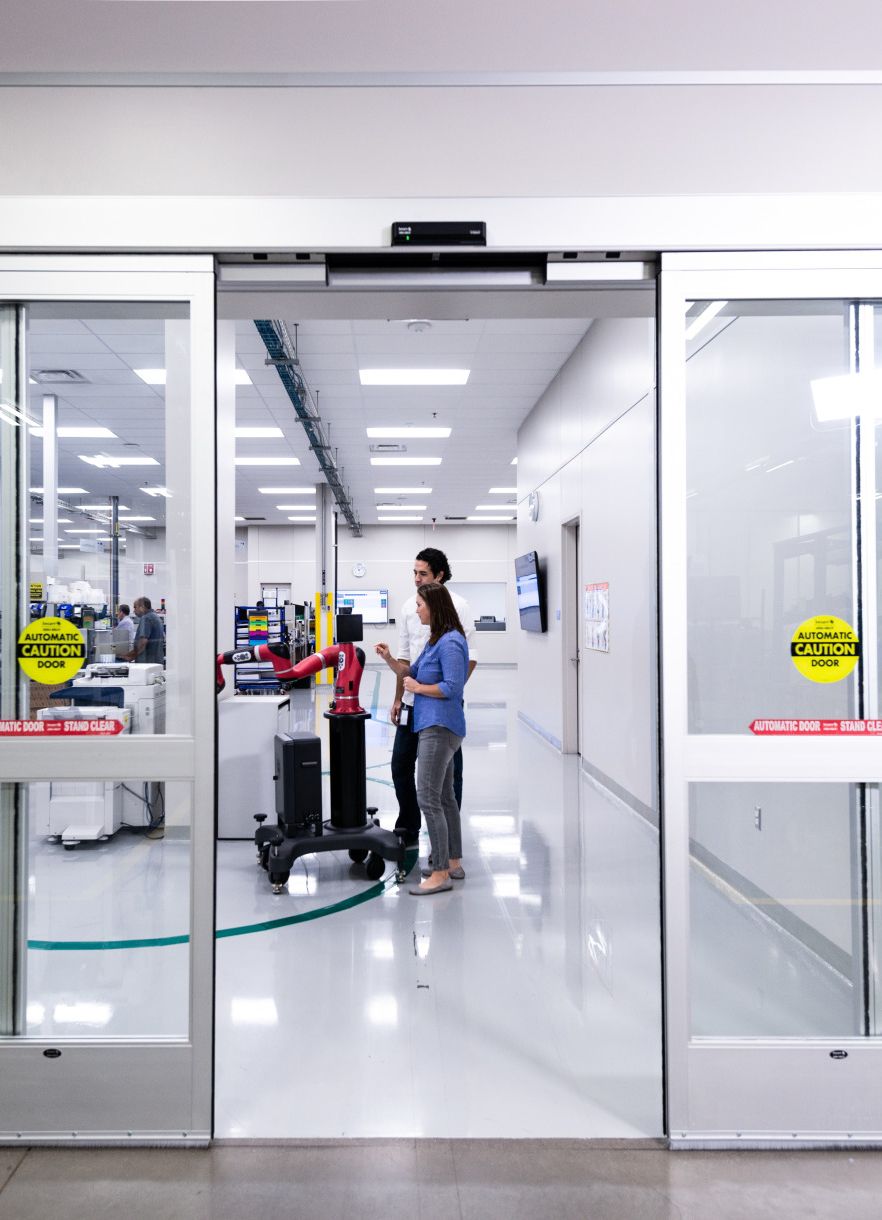 Des portes coulissantes s'ouvrent sur un bâtiment
