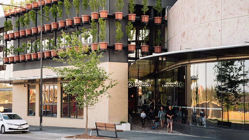 Byggnad med plantor i krukor placerade utanpå byggnadens fasad.