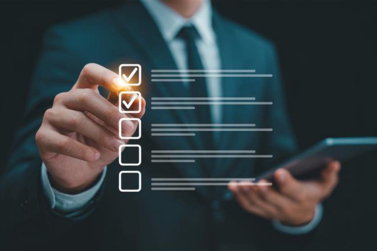 A closeup showing male hand checking list to illustrate business audit checklist