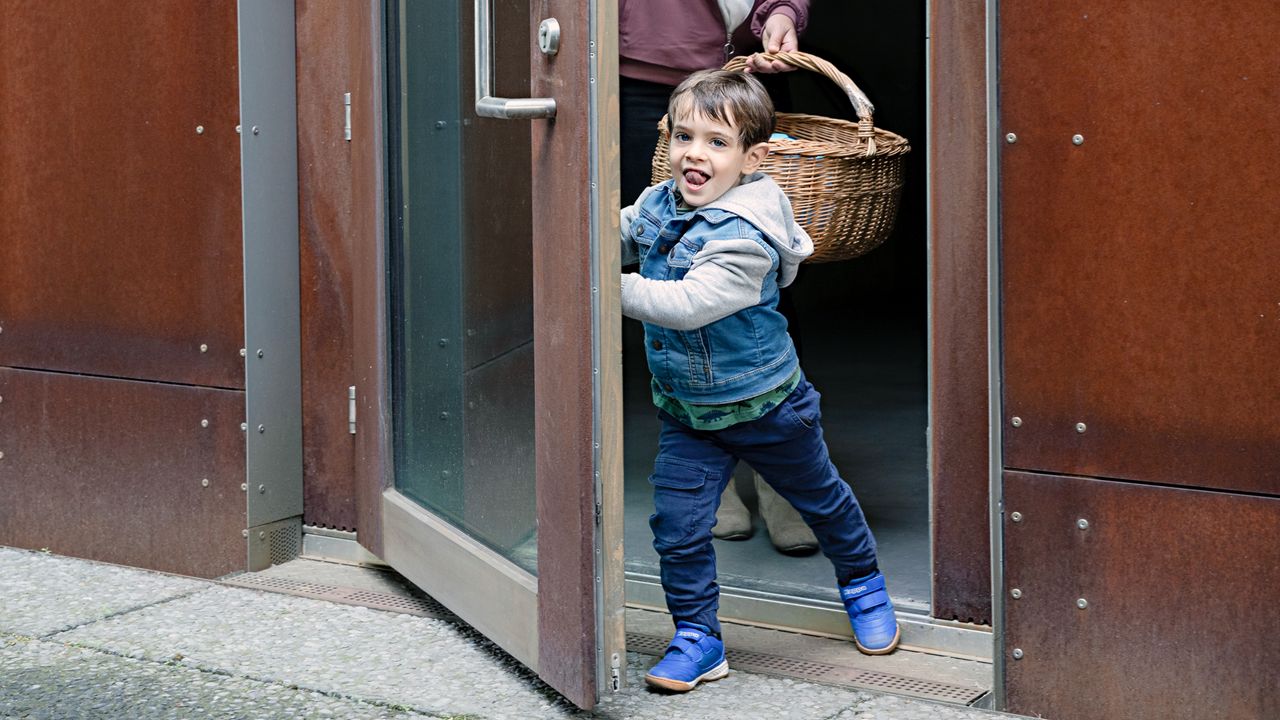 Kind loopt door deur met ASSA ABLOY deurpomp met Cam-Motion technologie